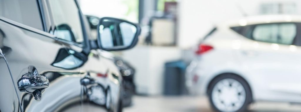 Close up of vehicle side view with distant white vehicle in background